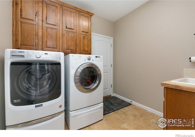 6582 Spanish Bay Dr, Windsor, CO 80550 - laundry room featuring washing machine and clothes dryer and cabinet space