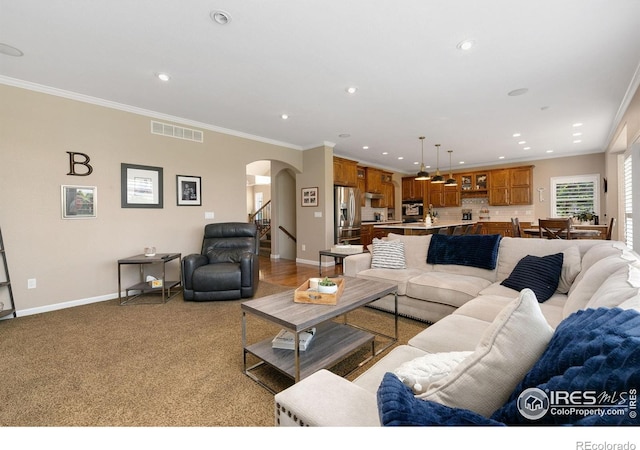 6582 Spanish Bay Dr, Windsor, CO 80550 - living area featuring arched walkways, recessed lighting, crown molding, and light colored carpet