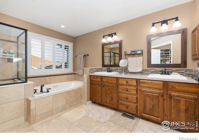 6582 Spanish Bay Dr, Windsor, CO 80550 - bathroom with a shower stall, double vanity, a garden tub, tasteful backsplash, and tile patterned floors