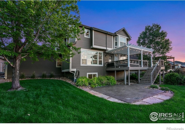 6582 Spanish Bay Dr, Windsor, CO 80550 - back of house at dusk featuring a pergola, a patio area, a wooden deck, stairs, and a yard