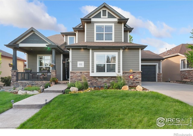 6582 Spanish Bay Dr, Windsor, CO 80550 - craftsman-style house featuring a porch, a front lawn, driveway, an attached garage, and stone siding