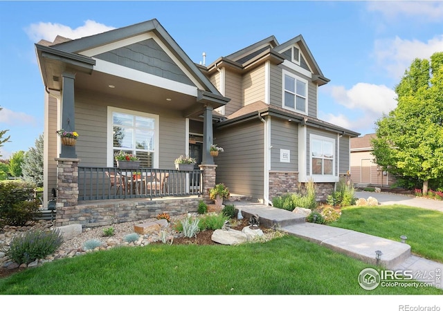 6582 Spanish Bay Dr, Windsor, CO 80550 - craftsman-style house with a front lawn, stone siding, and a porch