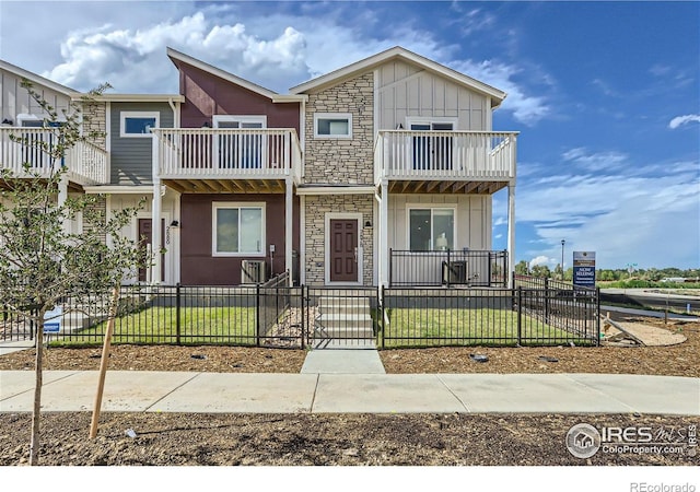 2770 Bear Springs Cir, Longmont, CO 80503 - multi unit property with board and batten siding, a balcony, stone siding, a fenced front yard, and a gate