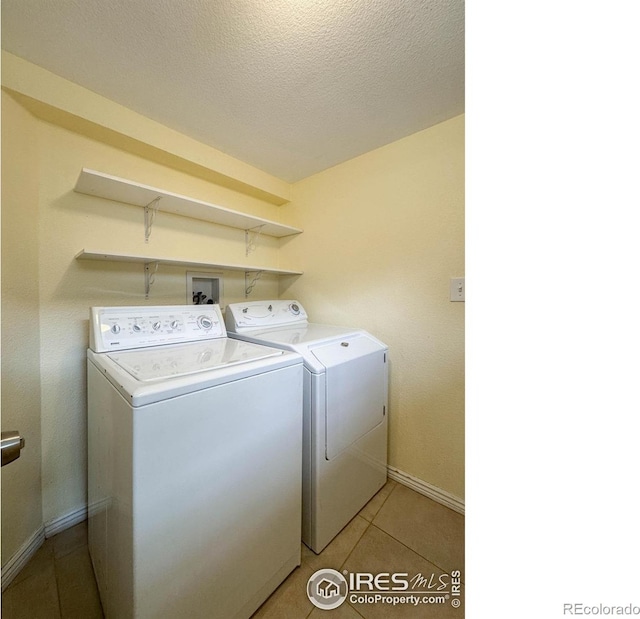 1750 Trenton St, Denver, CO 80220 - laundry area with washer and clothes dryer, light tile patterned floors, and a textured ceiling