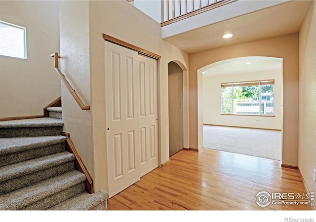 3268 White Buffalo Dr, Wellington, CO 80549 - stairway with arched walkways and wood finished floors