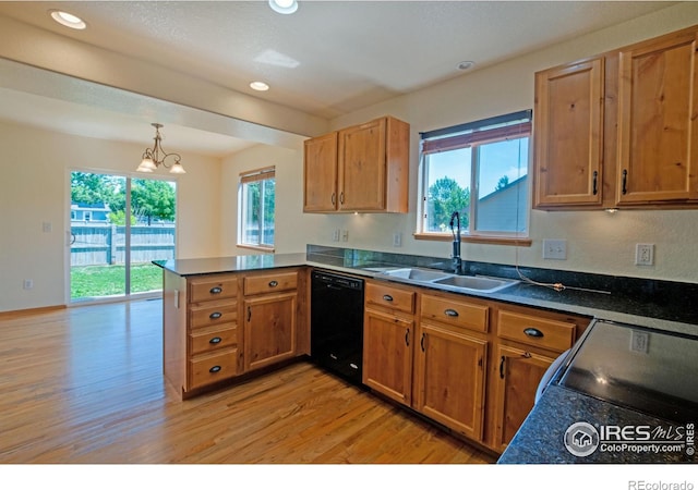 3268 White Buffalo Dr, Wellington, CO 80549 - kitchen with black appliances, a peninsula, light wood-type flooring, dark countertops, and brown cabinets
