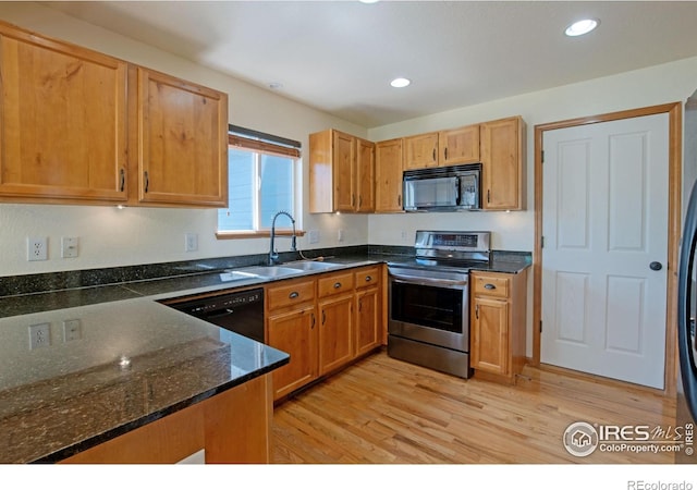 3268 White Buffalo Dr, Wellington, CO 80549 - kitchen with black appliances, light wood-style floors, recessed lighting, and dark stone countertops