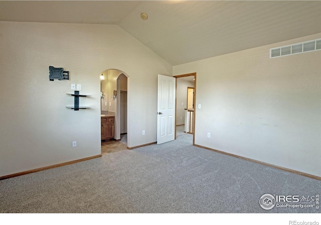 3268 White Buffalo Dr, Wellington, CO 80549 - unfurnished bedroom with arched walkways, carpet, vaulted ceiling, and ensuite bath