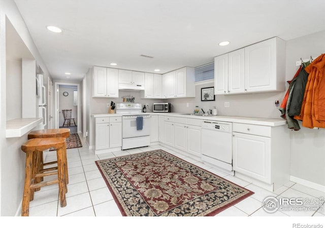 408 Riddle Dr, Fort Collins, CO 80521 - kitchen featuring white appliances, under cabinet range hood, white cabinetry, light tile patterned floors, and recessed lighting