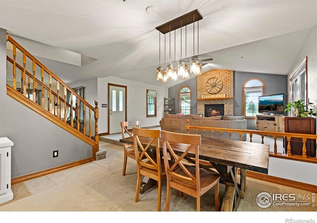 991 Peaceful View Pl, Johnstown, CO 80534 - carpeted dining space with lofted ceiling, stairway, and a brick fireplace