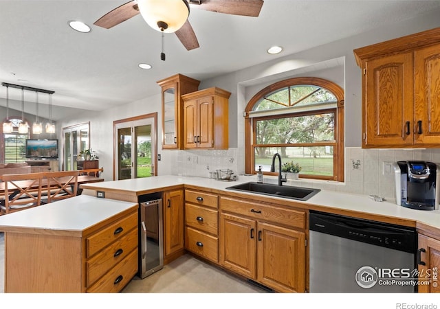 991 Peaceful View Pl, Johnstown, CO 80534 - kitchen with stainless steel dishwasher, a peninsula, ceiling fan, light countertops, and decorative backsplash
