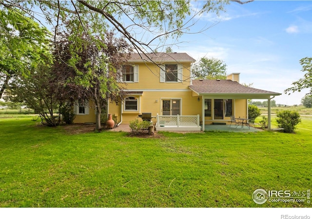 991 Peaceful View Pl, Johnstown, CO 80534 - back of house featuring a patio, a yard, and a chimney