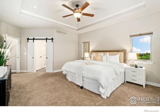 5954 Black Lion Ct, Windsor, CO 80550 - bedroom featuring a tray ceiling, carpet floors, a ceiling fan, and a barn door