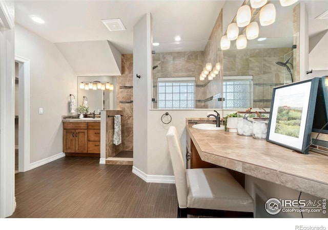 5954 Black Lion Ct, Windsor, CO 80550 - bathroom with walk in shower, two vanities, wood finished floors, and recessed lighting