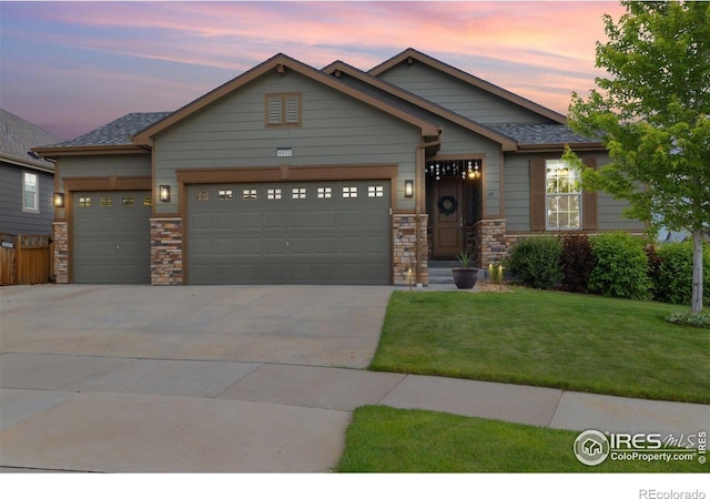 4822 Wildflower Pl, Dacono, CO 80514 - craftsman-style house with a garage, driveway, a yard, and stone siding