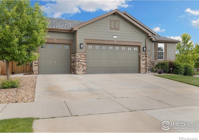 4822 Wildflower Pl, Dacono, CO 80514 - single story home featuring an attached garage, driveway, and stone siding