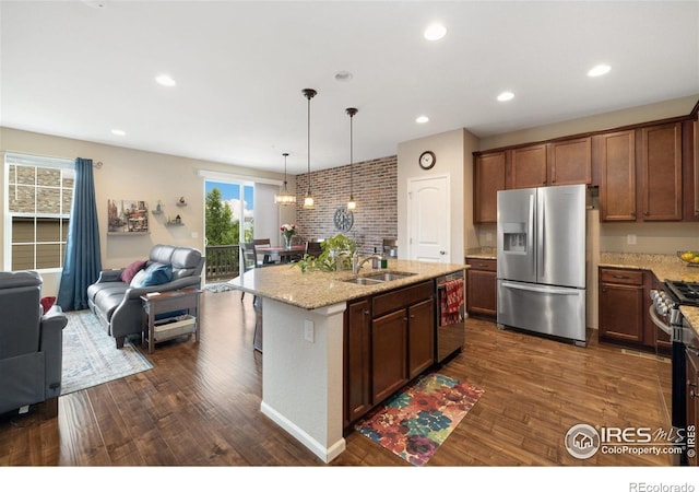 4822 Wildflower Pl, Dacono, CO 80514 - kitchen featuring stainless steel appliances, open floor plan, dark wood-style flooring, light stone counters, and hanging light fixtures