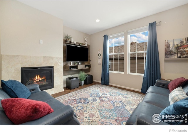 4822 Wildflower Pl, Dacono, CO 80514 - living room featuring wood finished floors, a tile fireplace, and recessed lighting