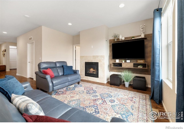 4822 Wildflower Pl, Dacono, CO 80514 - living area featuring wood finished floors, a tiled fireplace, and recessed lighting