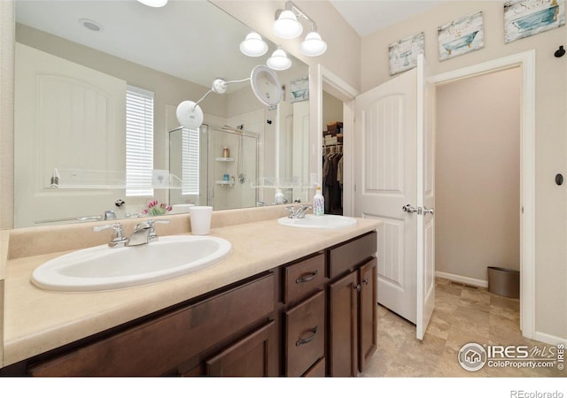 4822 Wildflower Pl, Dacono, CO 80514 - bathroom featuring a shower stall, double vanity, and a spacious closet