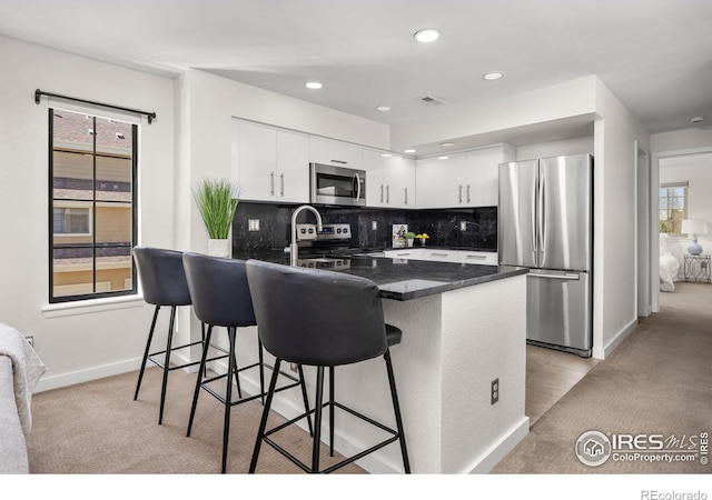 5904 Gunbarrel Ave Unit B, Boulder, CO 80301 - kitchen featuring appliances with stainless steel finishes, a peninsula, light colored carpet, a breakfast bar area, and recessed lighting