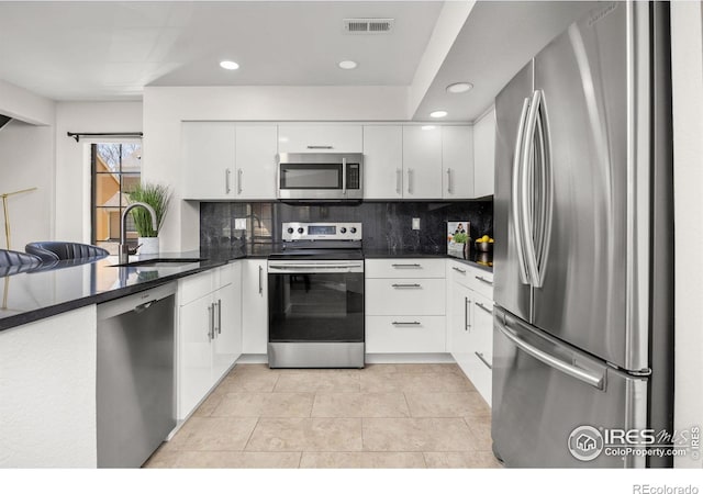 5904 Gunbarrel Ave Unit B, Boulder, CO 80301 - kitchen featuring stainless steel appliances, backsplash, white cabinetry, a peninsula, and recessed lighting