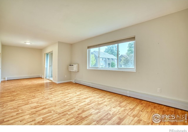 801 E Drake Rd Unit G77, Fort Collins, CO 80525 - spare room featuring a baseboard radiator, wood finished floors, and an AC wall unit