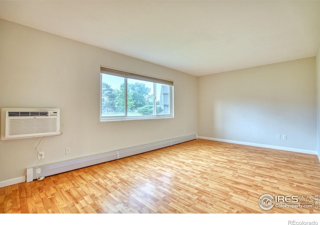 801 E Drake Rd Unit G77, Fort Collins, CO 80525 - spare room featuring baseboard heating, wood finished floors, and a wall mounted air conditioner