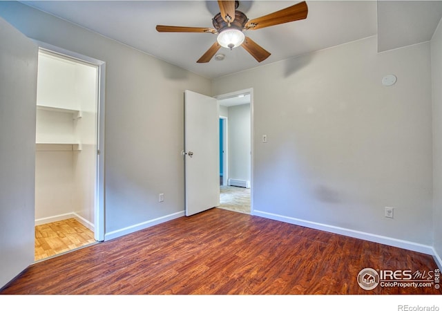 801 E Drake Rd Unit G77, Fort Collins, CO 80525 - unfurnished bedroom featuring wood finished floors, a baseboard radiator, a closet, a ceiling fan, and a spacious closet