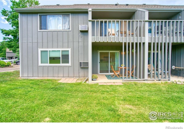 801 E Drake Rd Unit G77, Fort Collins, CO 80525 - rear view of house featuring board and batten siding, a yard, a patio area, an AC wall unit, and a balcony