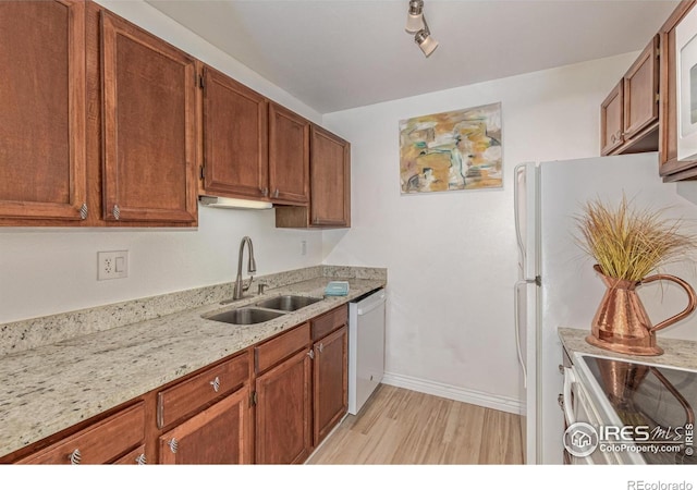 1410 Bacchus Dr Unit B12, Lafayette, CO 80026 - kitchen with white appliances, brown cabinetry, light wood-type flooring, and light stone counters
