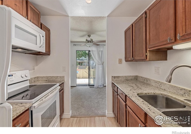 1410 Bacchus Dr Unit B12, Lafayette, CO 80026 - kitchen with white appliances, a ceiling fan, brown cabinets, light wood-style flooring, and a textured ceiling