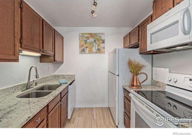 1410 Bacchus Dr Unit B12, Lafayette, CO 80026 - kitchen with white appliances, brown cabinets, light stone counters, and light wood finished floors