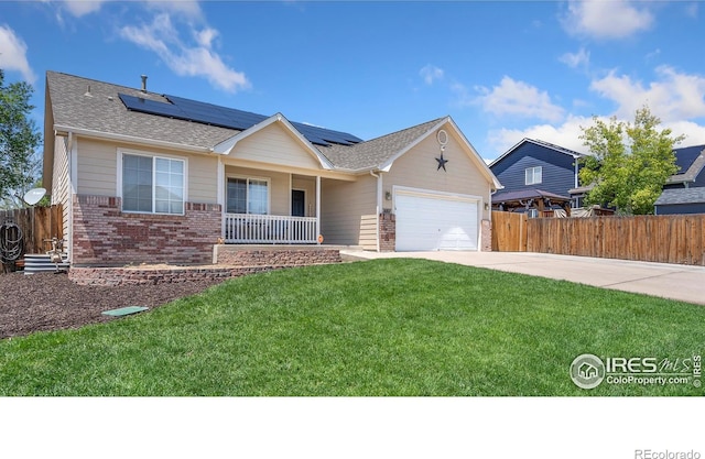 3007 45th Ave, Greeley, CO 80634 - ranch-style home featuring a porch, brick siding, concrete driveway, roof mounted solar panels, and a garage