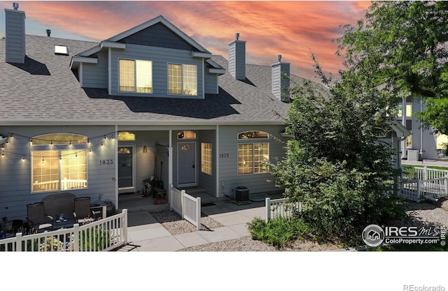 1839 Laurus Ln, Johnstown, CO 80534 - view of front of house featuring a shingled roof, a porch, and a chimney