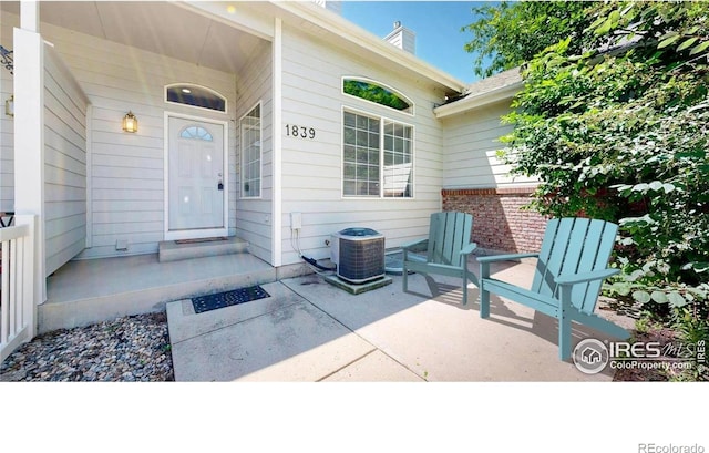 1839 Laurus Ln, Johnstown, CO 80534 - doorway to property featuring a chimney, brick siding, and a patio area