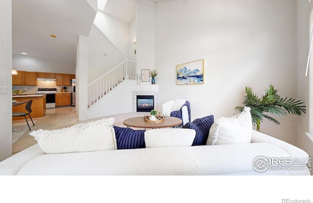 1839 Laurus Ln, Johnstown, CO 80534 - living room featuring a tiled fireplace, stairs, and a towering ceiling