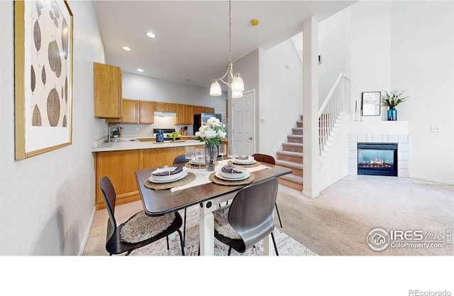 1839 Laurus Ln, Johnstown, CO 80534 - dining area with light carpet, recessed lighting, a high ceiling, a tile fireplace, and stairway