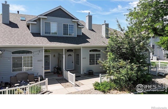 1839 Laurus Ln, Johnstown, CO 80534 - view of front of house with a shingled roof, a chimney, and covered porch