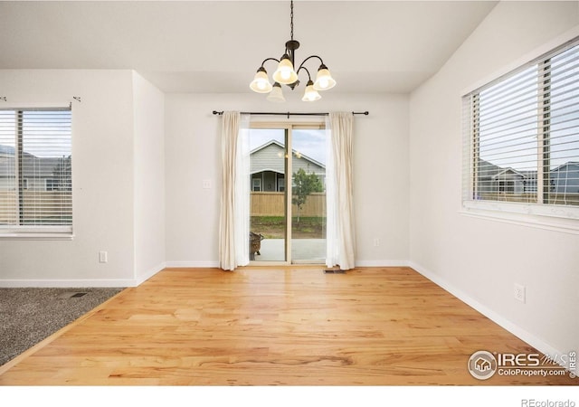 6818 Meadow Rain Way, Wellington, CO 80549 - unfurnished dining area featuring a chandelier and wood finished floors