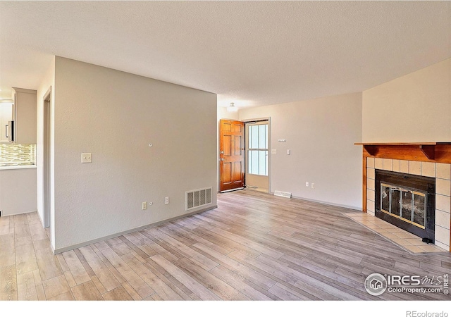 3405 W 16th St Unit 30, Greeley, CO 80634 - unfurnished living room with a tile fireplace and light wood-type flooring