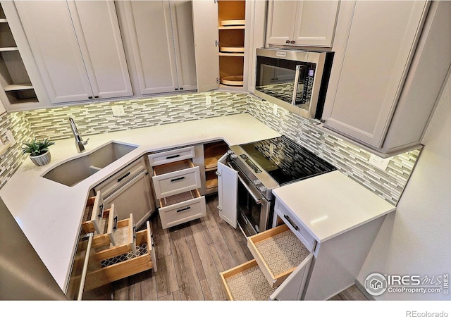 3405 W 16th St Unit 30, Greeley, CO 80634 - kitchen with stainless steel appliances, tasteful backsplash, wood finished floors, open shelves, and light countertops