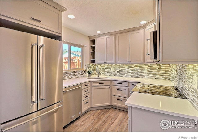 3405 W 16th St Unit 30, Greeley, CO 80634 - kitchen featuring appliances with stainless steel finishes, light countertops, backsplash, recessed lighting, and a textured ceiling