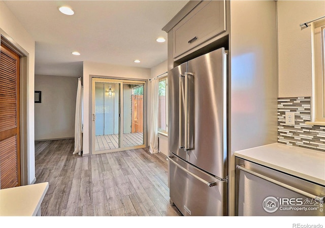 3405 W 16th St Unit 30, Greeley, CO 80634 - kitchen with high end refrigerator, light wood-style floors, backsplash, light countertops, and recessed lighting