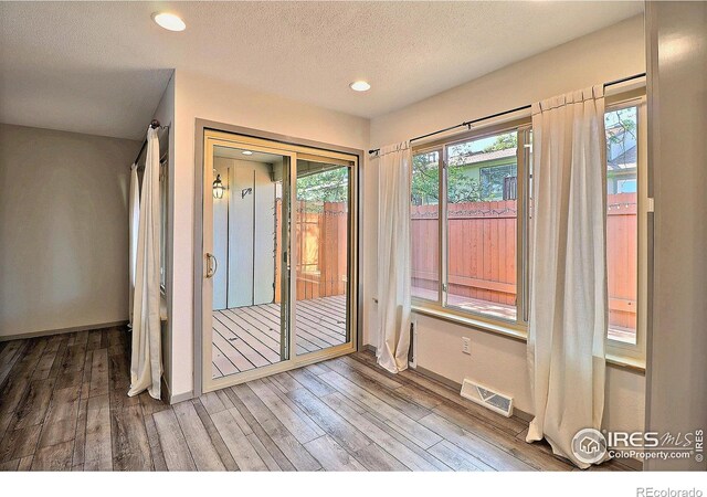 3405 W 16th St Unit 30, Greeley, CO 80634 - empty room featuring wood finished floors, recessed lighting, and a textured ceiling