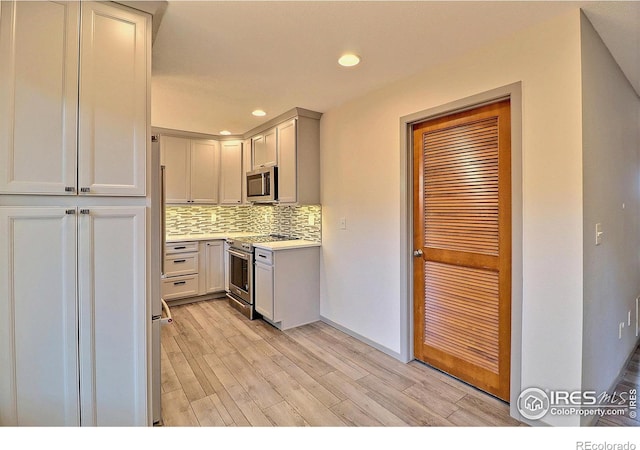 3405 W 16th St Unit 30, Greeley, CO 80634 - kitchen with appliances with stainless steel finishes, backsplash, light wood-type flooring, light countertops, and recessed lighting