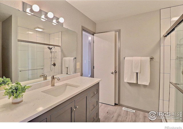 3405 W 16th St Unit 30, Greeley, CO 80634 - bathroom with wood finished floors, a tile shower, and vanity