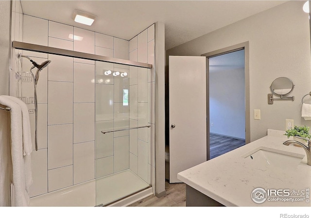 3405 W 16th St Unit 30, Greeley, CO 80634 - full bathroom with wood finished floors, a shower stall, and vanity