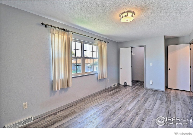 3405 W 16th St Unit 30, Greeley, CO 80634 - unfurnished bedroom with light wood-style flooring, a textured ceiling, and a closet