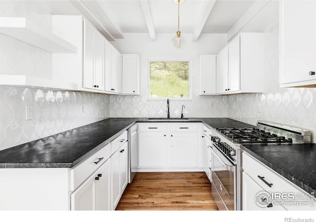 781 Cold Springs Rd, Nederland, CO 80466 - kitchen with stainless steel range with gas cooktop, beam ceiling, dark countertops, white cabinets, and wood finished floors